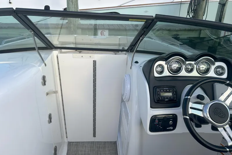 Slide: The Image of 2018 NauticStar 243DC Sport Deck boat dashboard with steering wheel and gauges. - 18