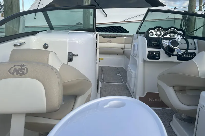 Slide: The Image of 2018 NauticStar 243DC Sport Deck interior with helm, seating, and dashboard. - 21