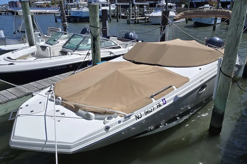 Slide: The Image of 2018 NauticStar 243DC Sport Deck boat docked with tan covers. - 3