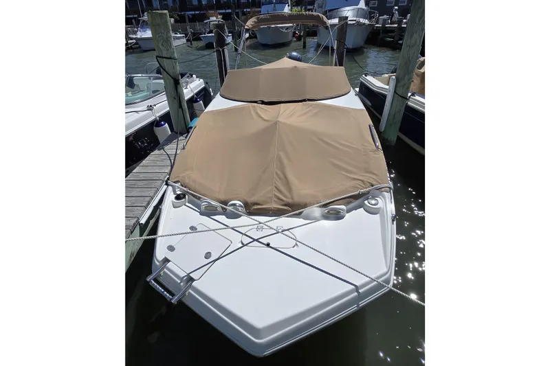Slide: The Image of 2018 NauticStar 243DC Sport Deck boat docked with tan cover. - 4
