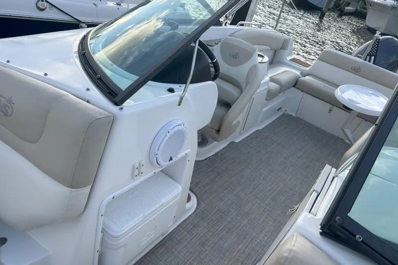 Slide: The Image of 2018 NauticStar 243DC Sport Deck boat interior with seating and steering wheel. - 6