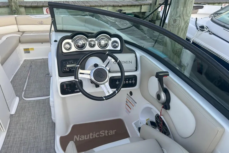 Slide: The Image of 2018 NauticStar 243DC Sport Deck boat interior with steering wheel and dashboard controls. - 7