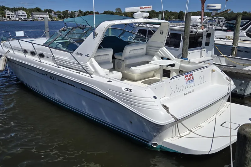 The Image of 1994 Sea Ray 400 Express Cruiser docked, white exterior, "For Sale" sign visible. - 0