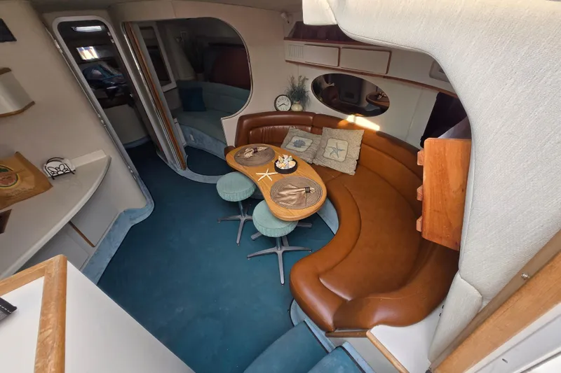 Slide: The Image of Interior of 1994 Sea Ray 400 Express Cruiser with curved seating and dining area. - 12