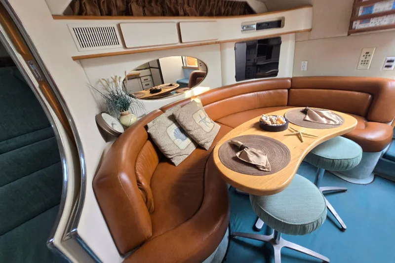 Slide: The Image of Interior of 1994 Sea Ray 400 Express Cruiser with curved seating and dining area. - 14
