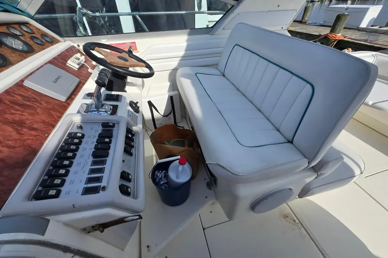Slide: The Image of 1994 Sea Ray 400 Express Cruiser helm with white seating and control panel. - 17