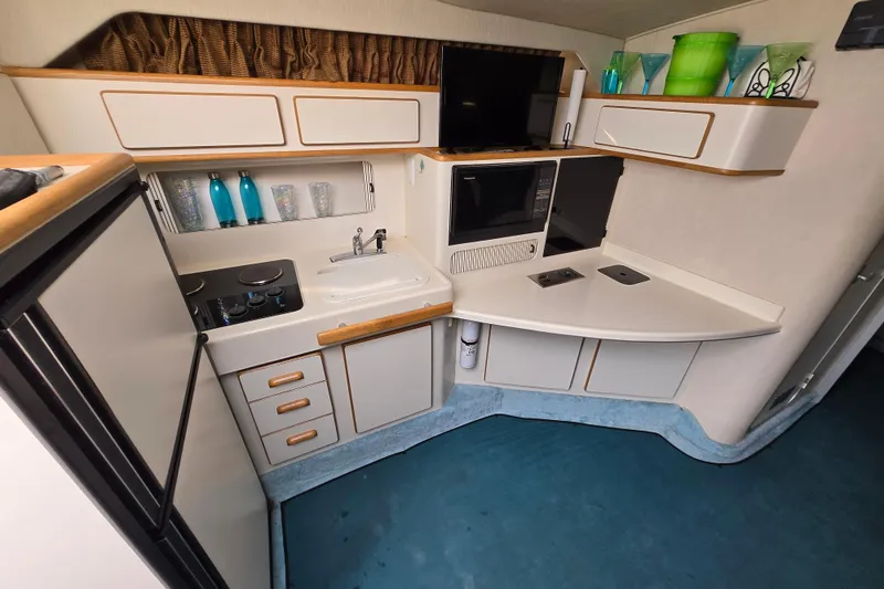 Slide: The Image of 1994 Sea Ray 400 Express Cruiser kitchen with modern appliances and sleek cabinetry. - 18