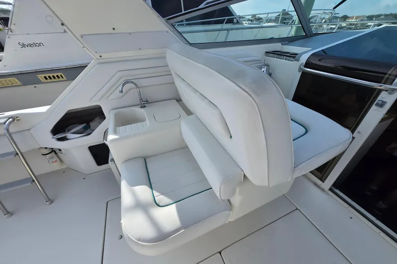 Slide: The Image of 1994 Sea Ray 400 Express Cruiser interior with white seating and built-in sink. - 25