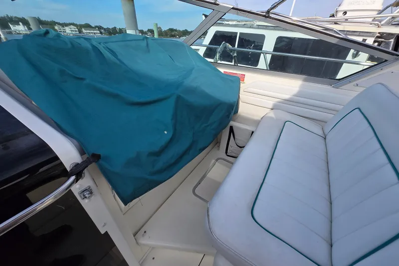 Slide: The Image of 1994 Sea Ray 400 Express Cruiser interior with white seating and teal cover. - 40