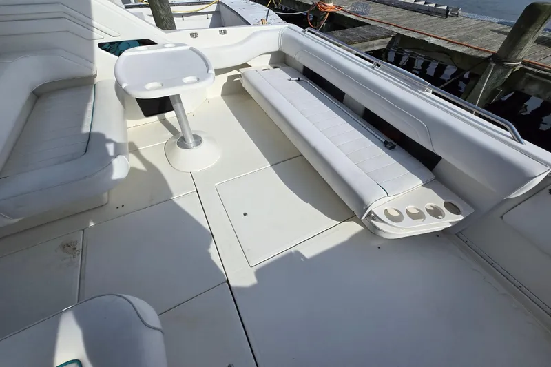 Slide: The Image of 1994 Sea Ray 400 Express Cruiser deck with seating and table, dockside view. - 9
