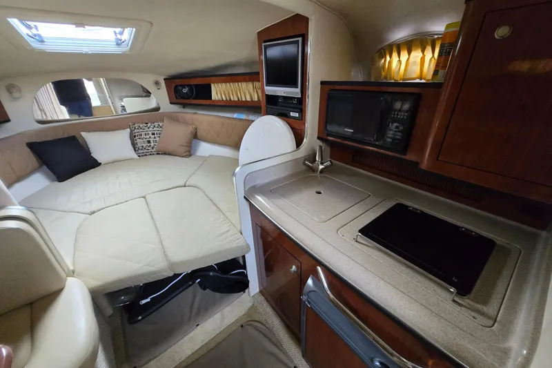 Slide: The Image of Interior of 2006 Sea Ray 280 Sundancer with cozy bed and compact kitchen area. - 7