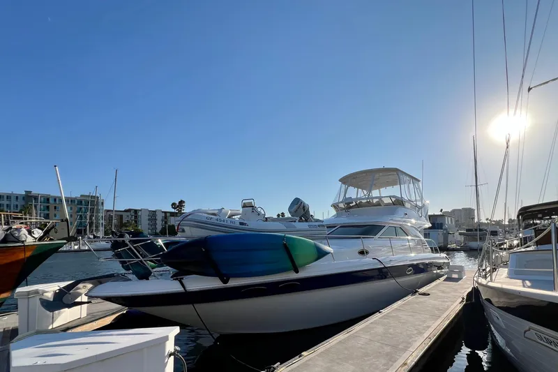 Slide: The Image of 2000 Sea Ray 400 Sedan Bridge yacht docked in marina under clear blue sky. - 1