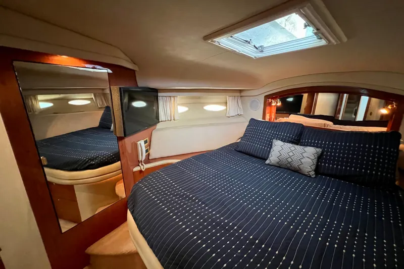 Slide: The Image of Luxurious bedroom interior of 2000 Sea Ray 400 Sedan Bridge yacht with skylight and TV. - 112