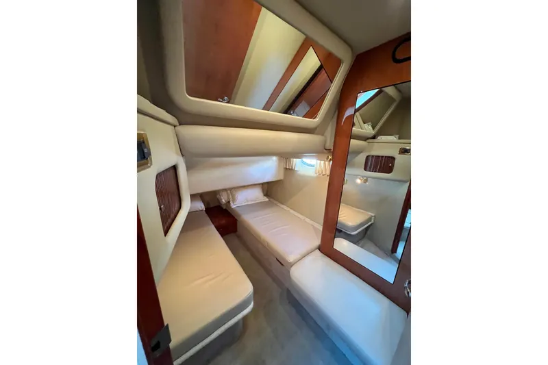 Slide: The Image of 2000 Sea Ray 400 Sedan Bridge cabin interior with cozy beds and wooden accents. - 124