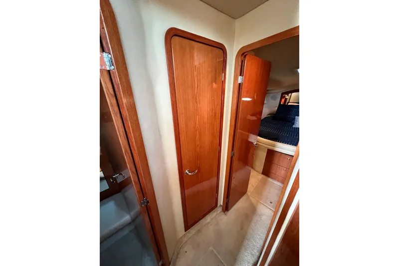 Slide: The Image of Interior view of 2000 Sea Ray 400 Sedan Bridge, featuring wooden doors and cozy bedroom. - 136