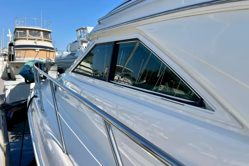 Slide: The Image of 2000 Sea Ray 400 Sedan Bridge yacht docked, showcasing sleek design and reflective windows. - 32