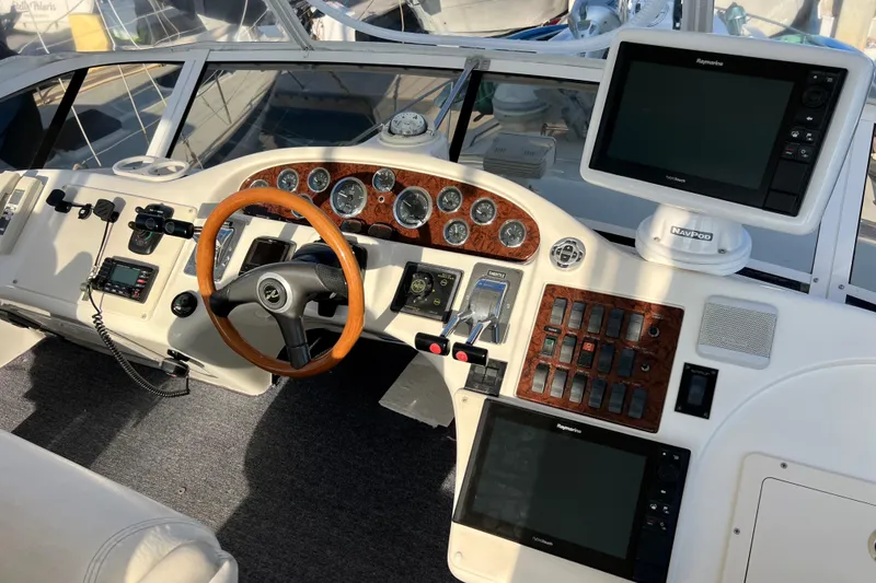 Slide: The Image of Cockpit of 2000 Sea Ray 400 Sedan Bridge with navigation equipment and wooden steering wheel. - 56