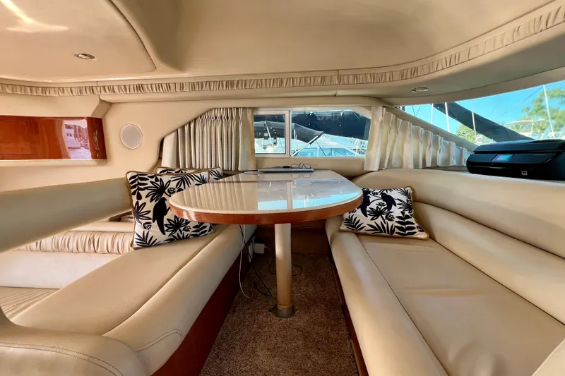 Slide: The Image of Luxurious interior of 2000 Sea Ray 400 Sedan Bridge yacht with elegant seating and table. - 84