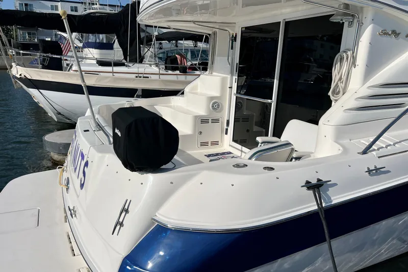 Slide: The Image of 2000 Sea Ray 400 Sedan Bridge yacht docked at marina, showcasing spacious deck area. - 9