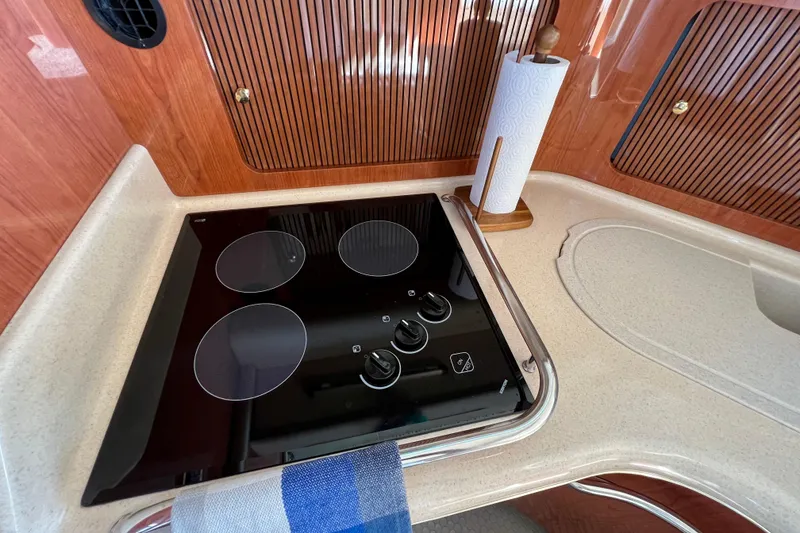 Slide: The Image of Modern kitchen in 2000 Sea Ray 400 Sedan Bridge yacht with stovetop and paper towel holder. - 96