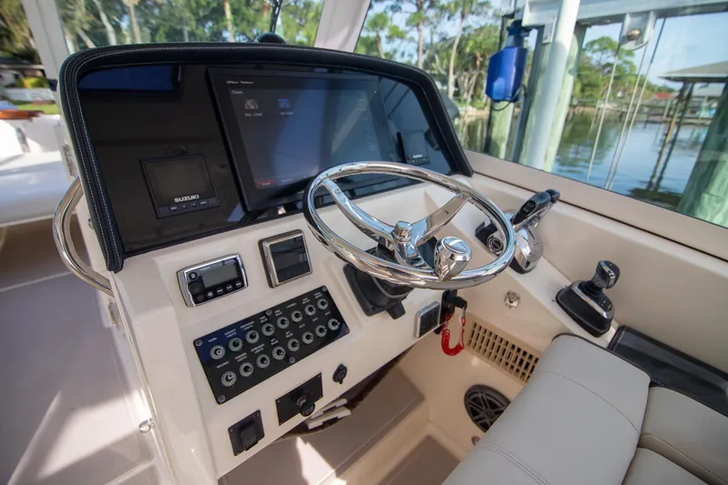 Slide: The Image of Cockpit of 2016 World Cat 320 DC boat with steering wheel and control panel. - 14