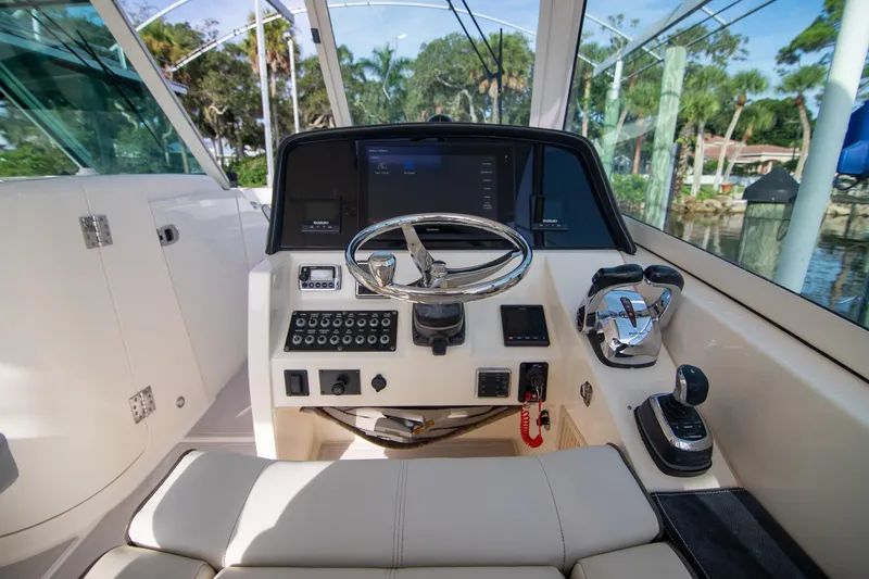 Slide: The Image of Helm of 2016 World Cat 320 DC boat with steering wheel and controls. - 15