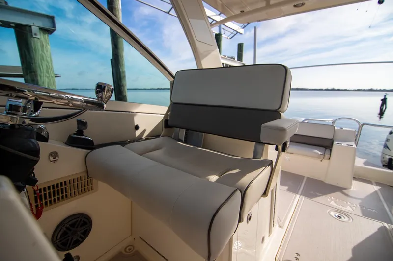 Slide: The Image of 2016 World Cat 320 DC boat interior with helm seat and serene water view. - 21