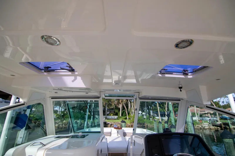 Slide: The Image of 2016 World Cat 320 DC boat interior with sunroof and modern dashboard. - 22