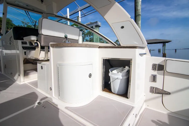 Slide: The Image of 2016 World Cat 320 DC boat interior with seating, storage, and sink. - 25