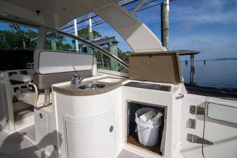 Slide: The Image of 2016 World Cat 320 DC boat interior with sink and storage, docked by the water. - 26
