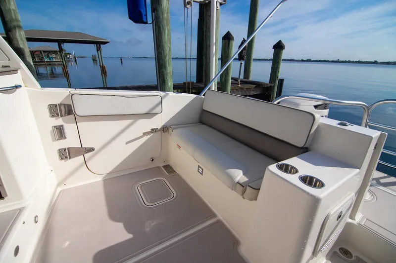 Slide: The Image of 2016 World Cat 320 DC boat interior with seating and cup holders by the dock. - 28