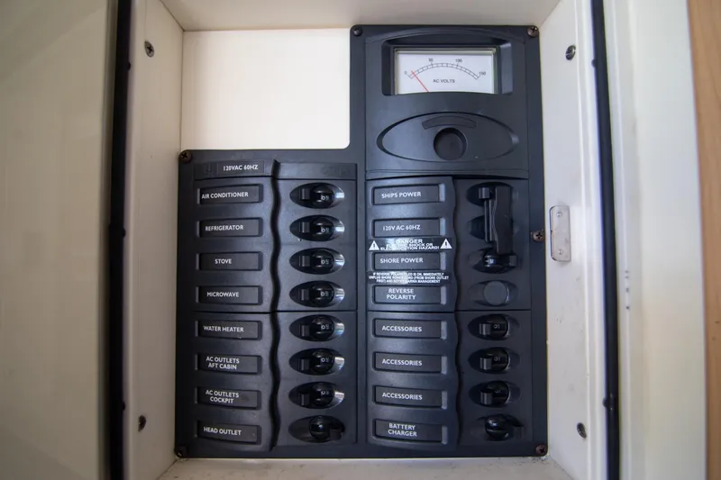 Slide: The Image of Electrical panel of a 2016 World Cat 320 DC boat, featuring labeled switches and voltmeter. - 33