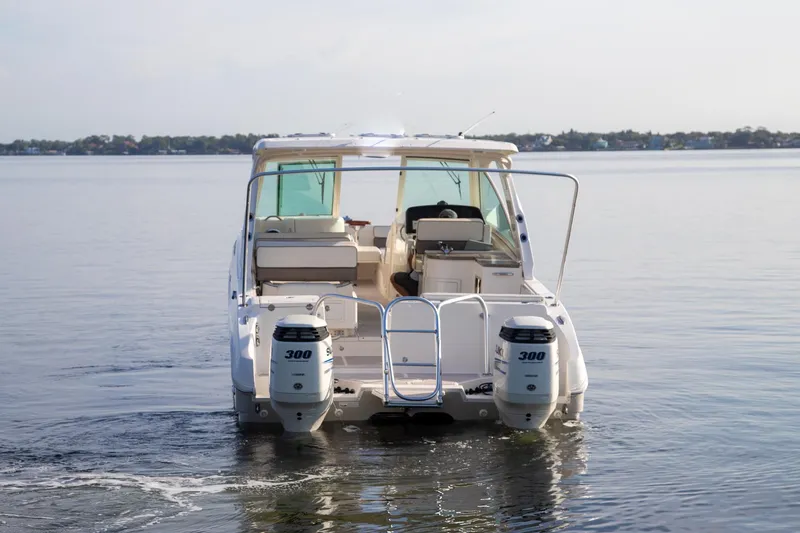 Slide: The Image of 2016 World Cat 320 DC boat on calm water, rear view with dual engines. - 4