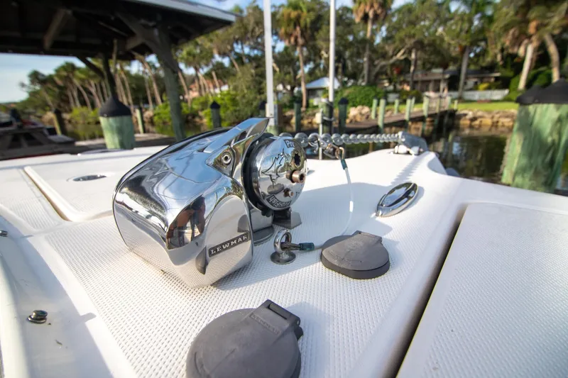 Slide: The Image of 2016 World Cat 320 DC boat deck with Lewmar anchor winch, docked near lush greenery. - 7