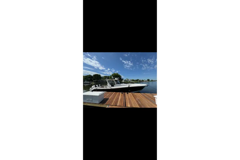 Slide: The Image of 2017 Edgewater 368CC boat docked on a sunny day with clear skies. - 15