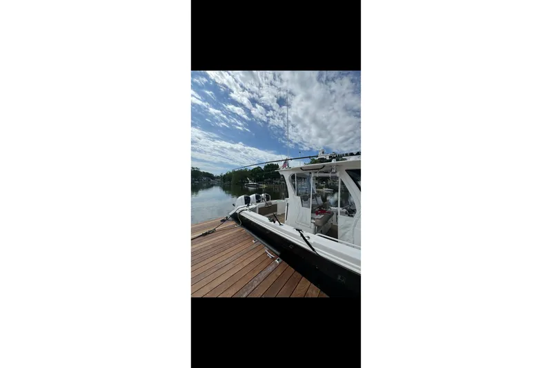 Slide: The Image of 2017 Edgewater 368CC boat docked on a sunny day with cloudy sky. - 16