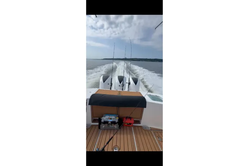Slide: The Image of 2017 Edgewater 368CC boat cruising with fishing rods, wake trail visible. - 17