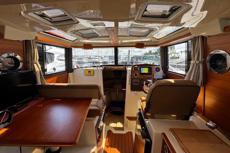 Slide: The Image of Interior of 2023 Ranger Tugs R-23 boat, featuring helm, seating, and wood accents. - 4