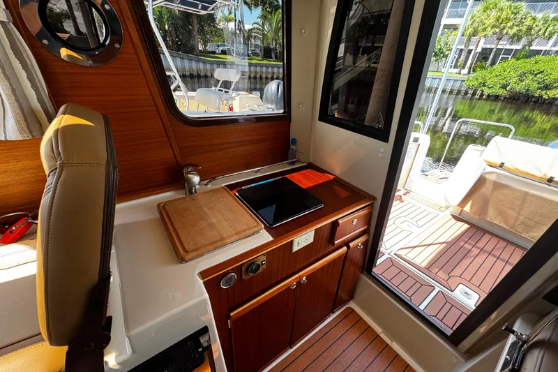 Slide: The Image of Interior of 2023 Ranger Tugs R-23 boat with kitchenette and outdoor view. - 6