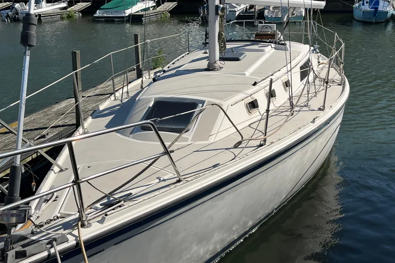 The Image of 1985 O'Day 35 sailboat docked in a marina, showcasing its sleek design and spacious deck. - 0
