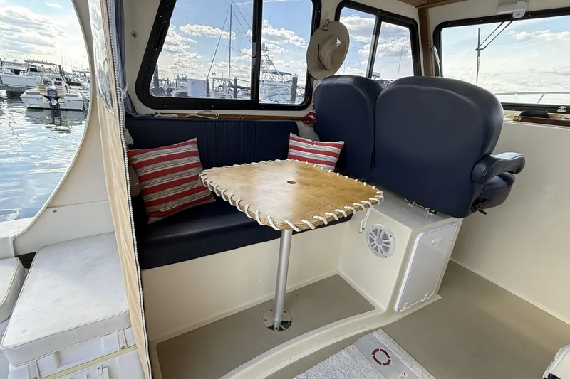 Slide: The Image of Interior of 2020 Eastern Islander 270 boat with seating and table, docked at marina. - 12