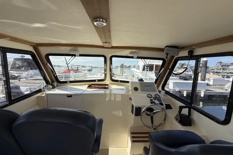 Slide: The Image of Interior view of 2020 Eastern Islander 270 boat cockpit with marina background. - 8