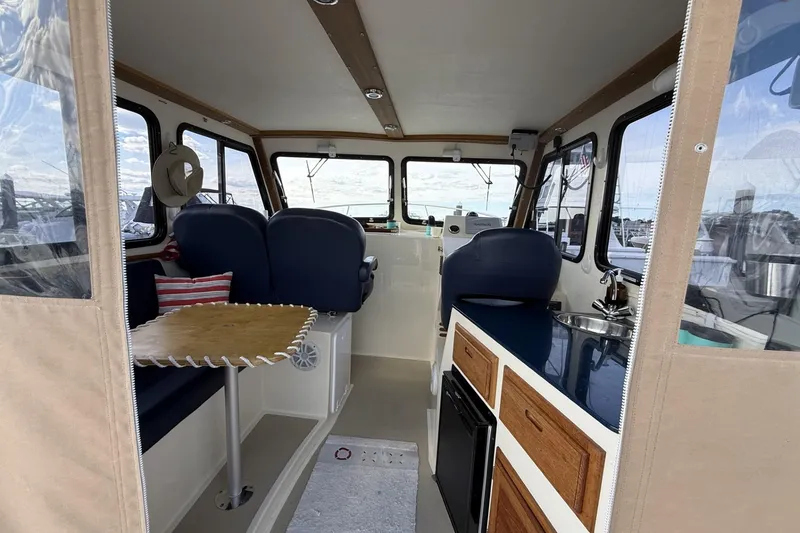 Slide: The Image of Interior of 2020 Eastern Islander 270 boat with seating, table, and kitchenette. - 9
