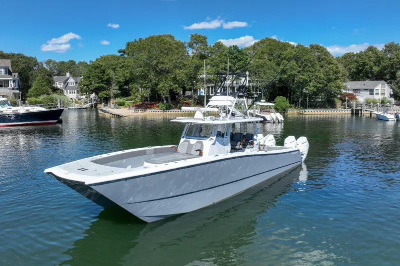 Slide: The Image of 2025 Freeman 42 LR boat on serene water near lush shoreline. - 10