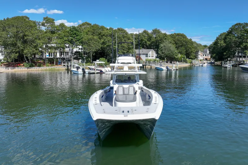 Slide: The Image of 2025 Freeman 42 LR boat on a serene waterway, surrounded by lush greenery and houses. - 11