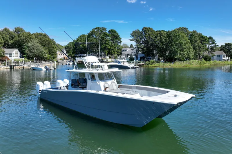 Slide: The Image of Freeman 42 LR 2025 boat on calm water, surrounded by trees and houses. - 12
