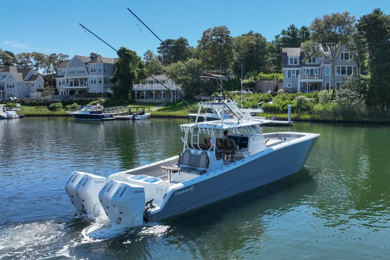 Slide: The Image of Freeman 42 LR 2025 boat cruising near waterfront homes on a sunny day. - 13