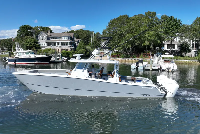 Slide: The Image of 2025 Freeman 42 LR boat cruising in a scenic waterfront setting. - 16