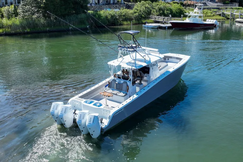 Slide: The Image of 2025 Freeman 42 LR boat with quad engines cruising in a serene waterway. - 17