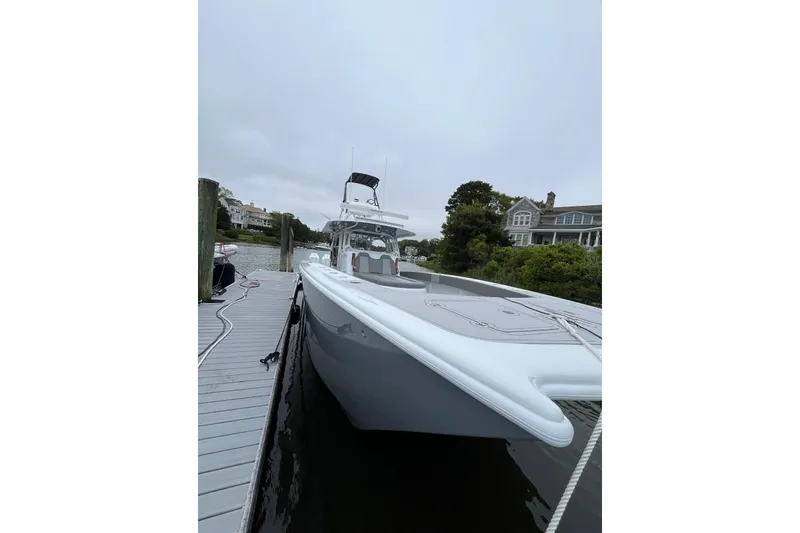 Slide: The Image of Freeman 42 LR 2025 boat docked by waterfront homes on a cloudy day. - 18